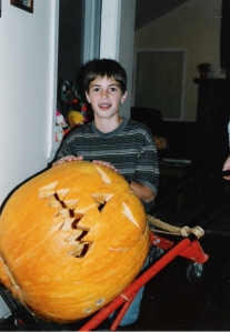 Jon pushing a large pumpkin carved as a jack-o-lantern